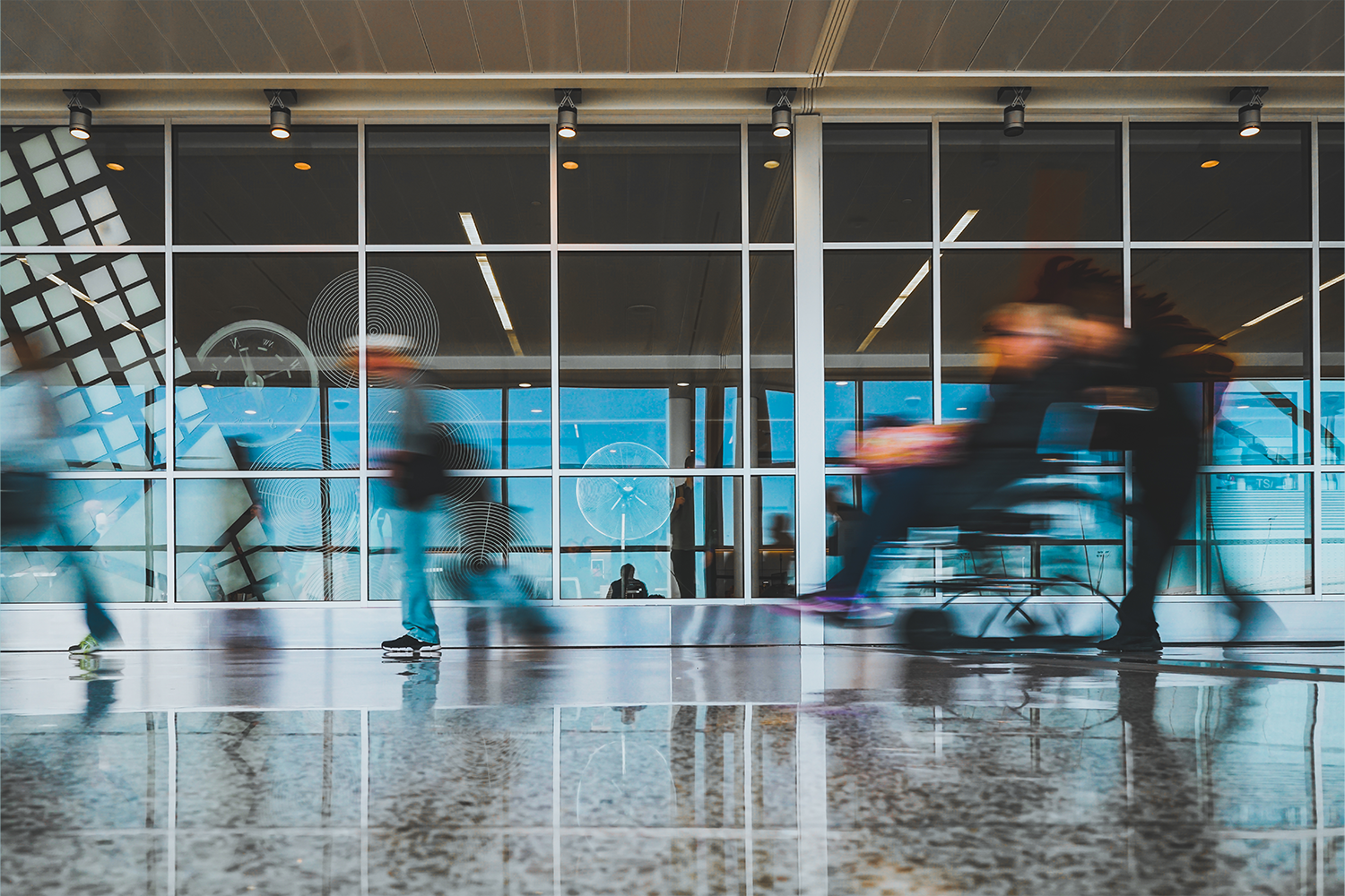 A blurry photo of a passenger being wheeled around in a wheelchair at an airport