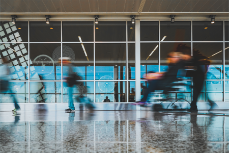 A blurry photo of a passenger being wheeled around in a wheelchair at an airport