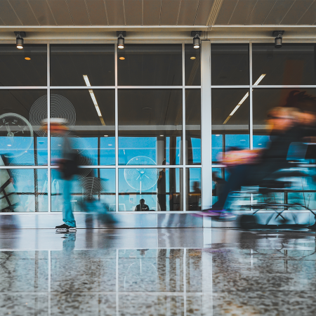 A blurry photo of a passenger being wheeled around in a wheelchair at an airport