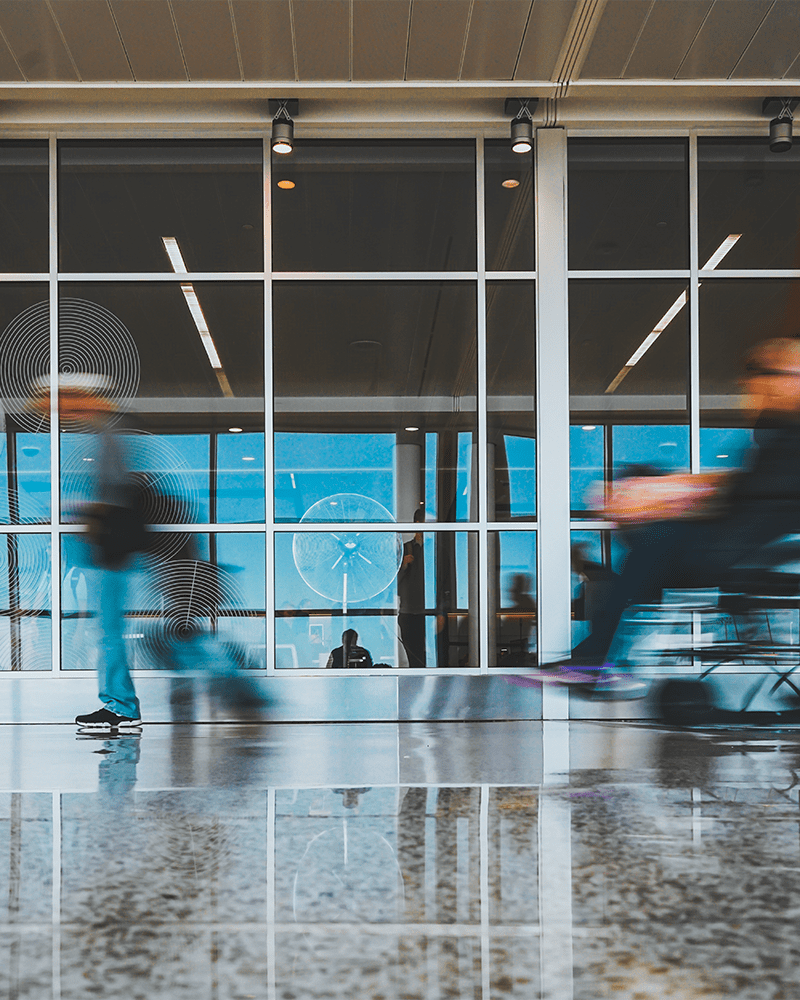A blurry photo of a passenger being wheeled around in a wheelchair at an airport