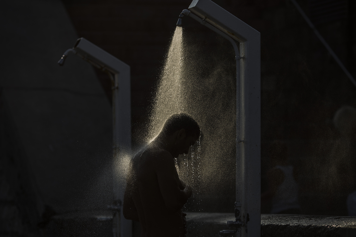 A man showering in the dark.