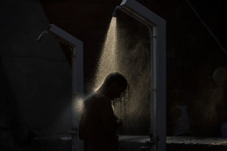 A man showering in the dark.