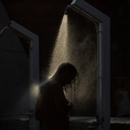 A man showering in the dark.