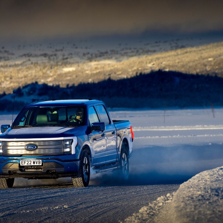 The all-electric Ford F-150 Lightning truck driving on an icy, snowy road