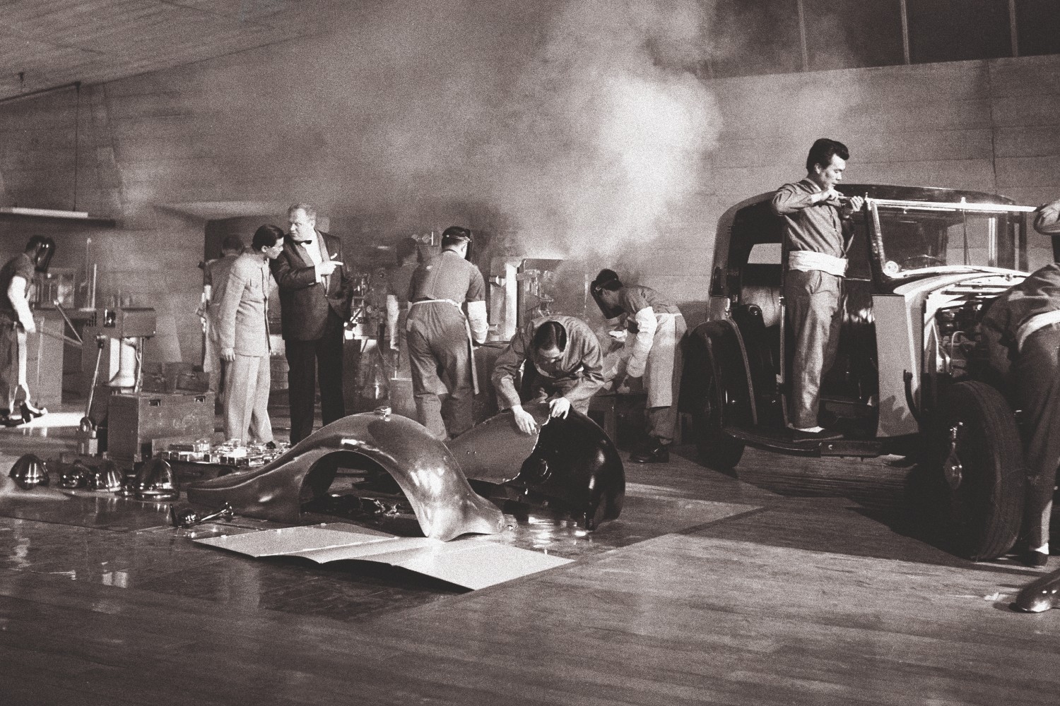 Technicians working on cars from Goldfinger