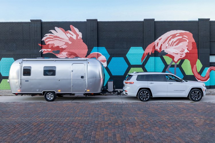 A white SUV towing the Airstream World Traveler, a new travel trailer that's spacious, affordable and easy to tow