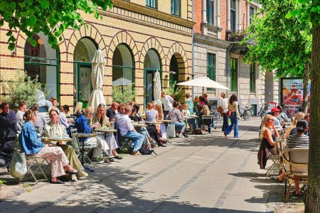 People enjoying outdoor dining at a sunny cafe