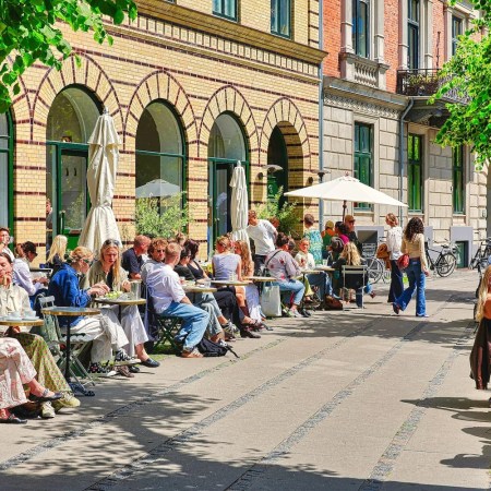 People enjoying outdoor dining at a sunny cafe