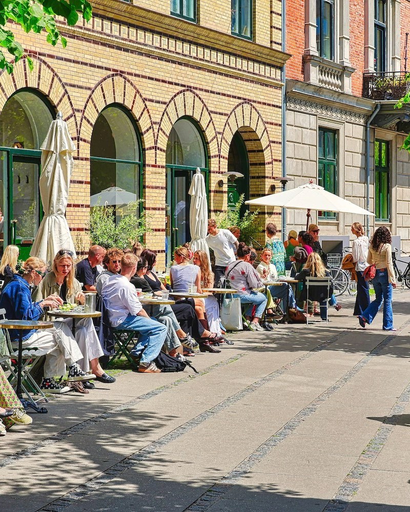People enjoying outdoor dining at a sunny cafe