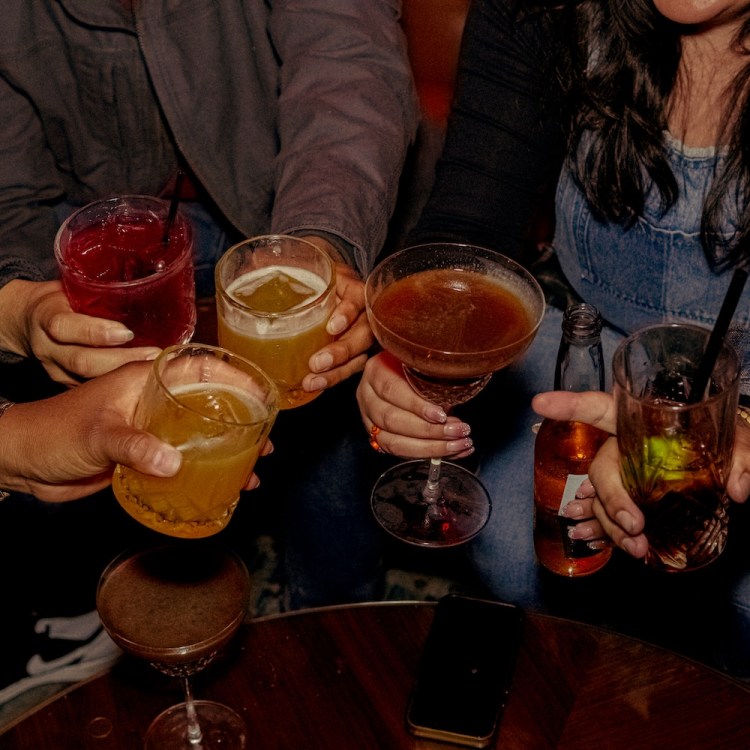 People holding cocktails together