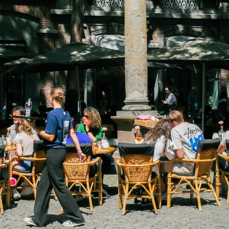 A waitress serving early dinner at an outdoor restaurant.