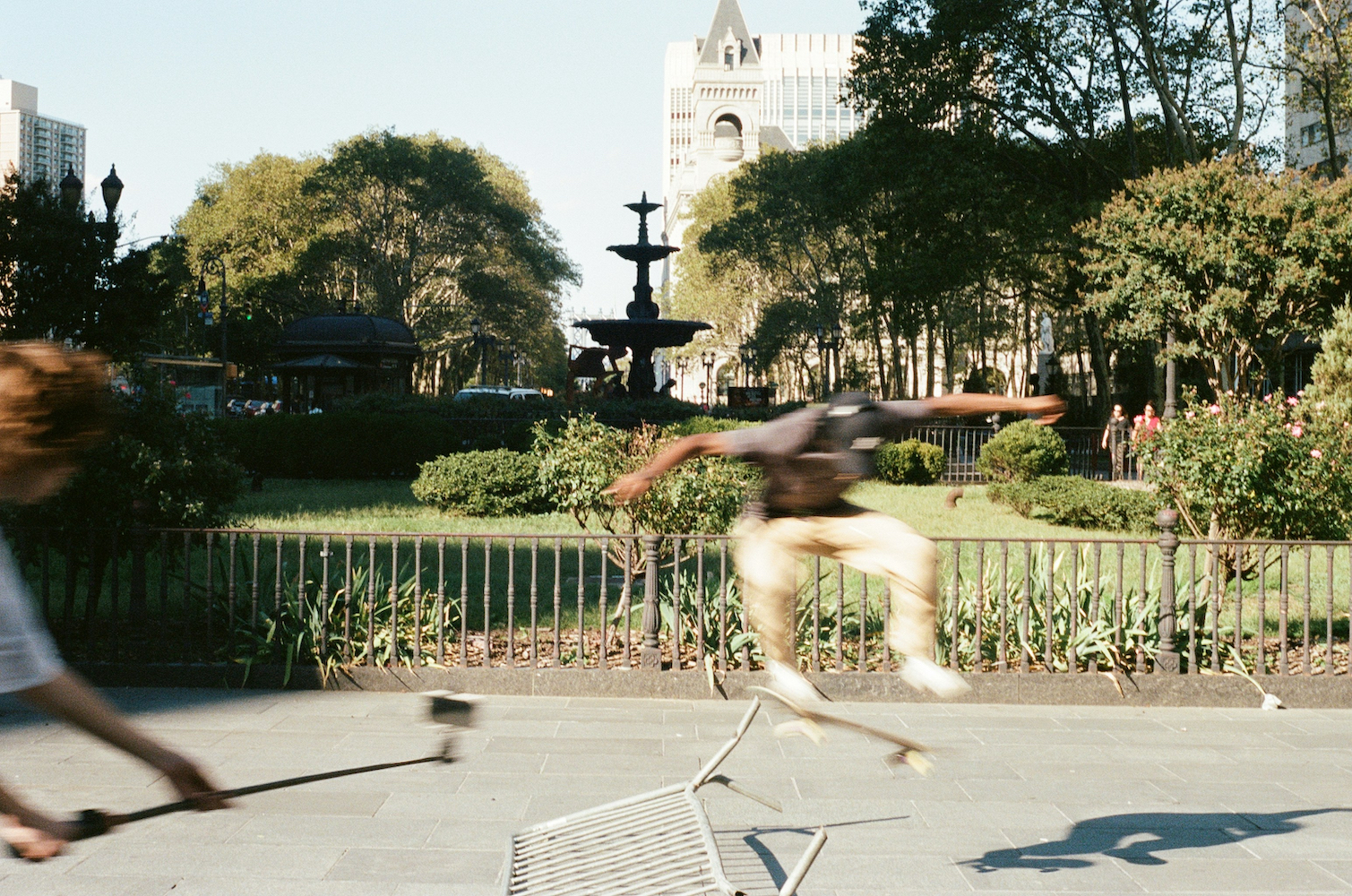 A pair of skaters doing tricks in a park.