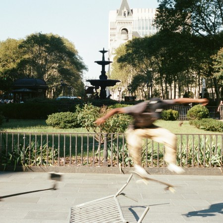 A pair of skaters doing tricks in a park.