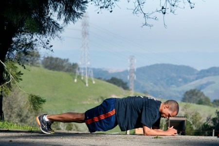 A man doing a plank outside.