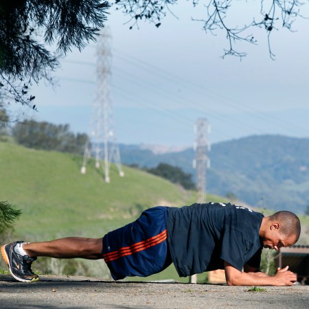 A man doing a plank outside.