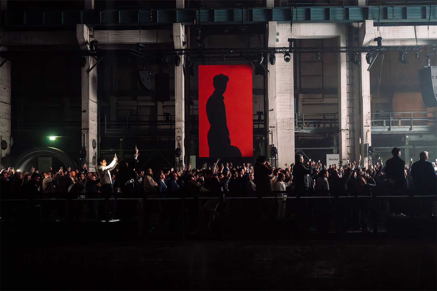 A red banner with F1 driver Gabriel Bortoleto shown in silhouette, at the Audi Revolut F1 Team launch event in Berlin