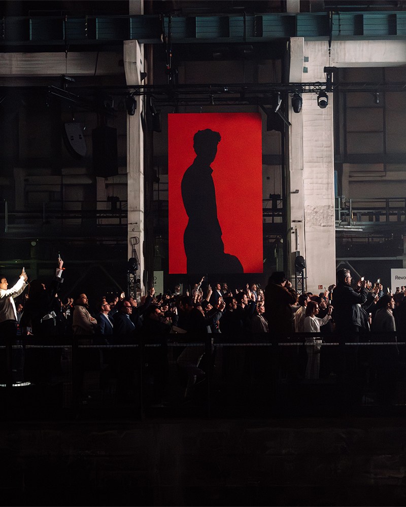 A red banner with F1 driver Gabriel Bortoleto shown in silhouette, at the Audi Revolut F1 Team launch event in Berlin
