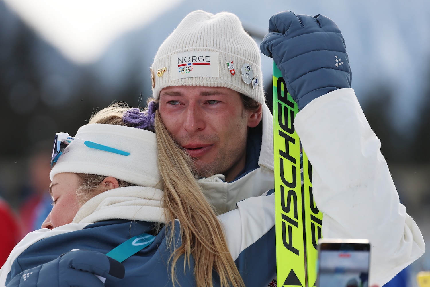 Bronze medalist Sturla Holm Laegreid of Team Norway is embraced by Ingrid Landmark Tandrevold of Team Norway after the medal ceremony