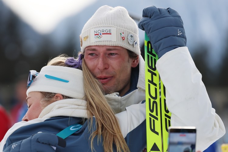 Bronze medalist Sturla Holm Laegreid of Team Norway is embraced by Ingrid Landmark Tandrevold of Team Norway after the medal ceremony