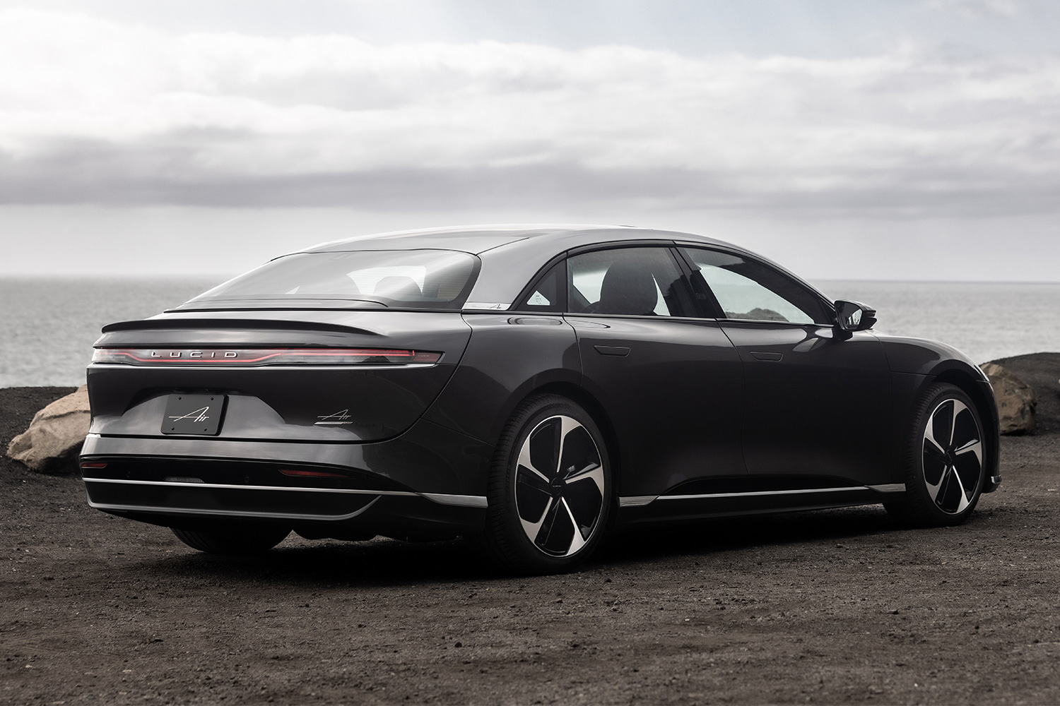 The Lucid Air, an electric sedan, parked near the ocean on a cloudy day