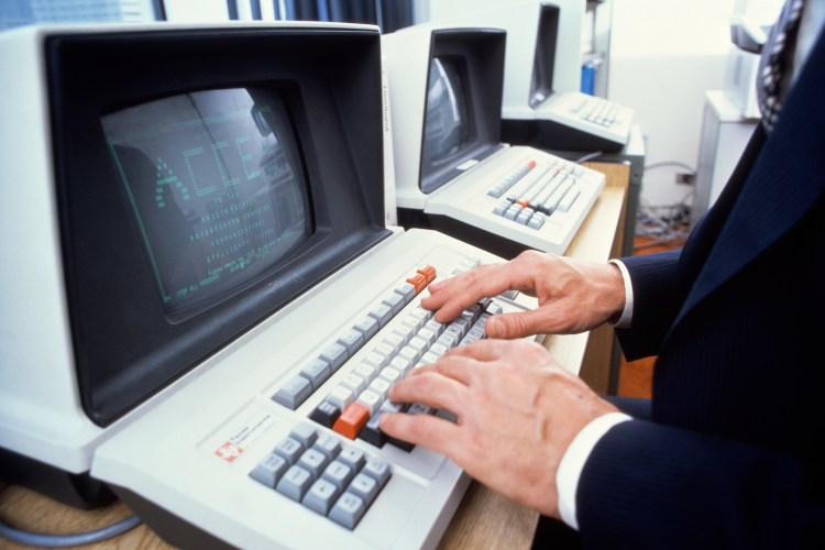 A man typing on an old keyboard.
