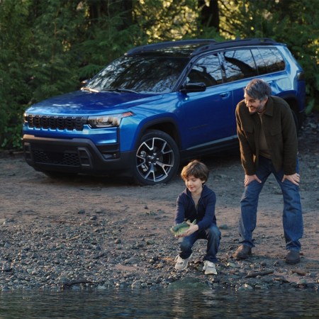 A still image from Jeep's Super Bowl ad from 2026, "Billy Goes to the River," which shows a boy setting a Big Mouth Billy Bass free alongside his dad and a 2026 Jeep Cherokee hybrid
