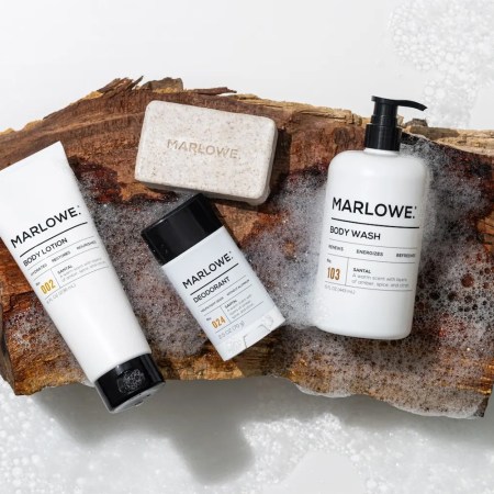 Marlowe body lotion, deodorant, body wash, and bar soap on a piece of wood