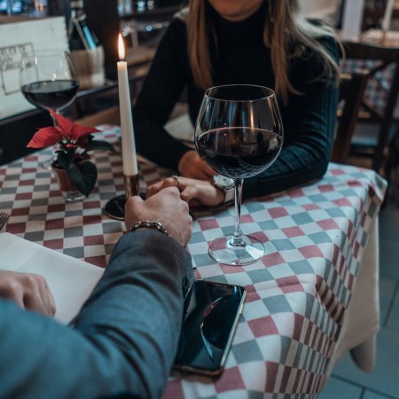 A couple holding hands over a table while on a date