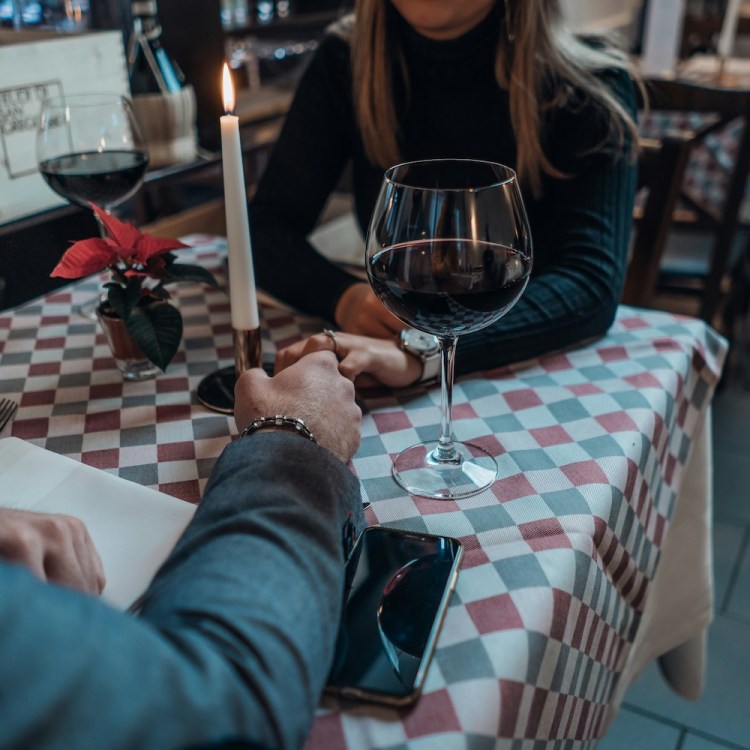 A couple holding hands over a table while on a date