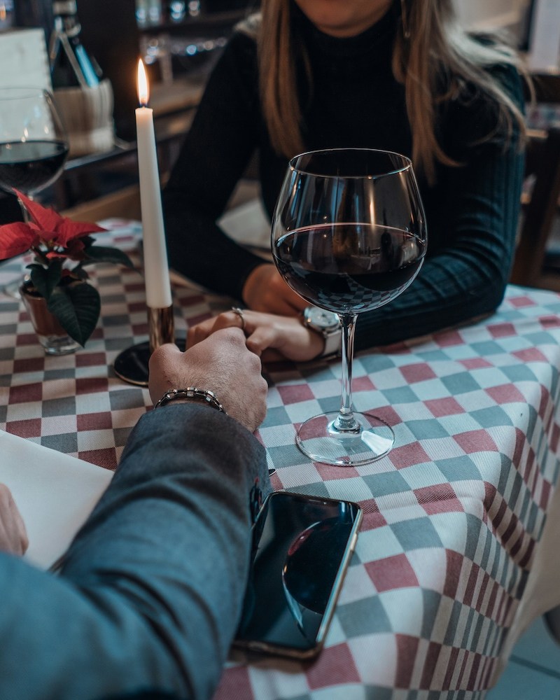 A couple holding hands over a table while on a date