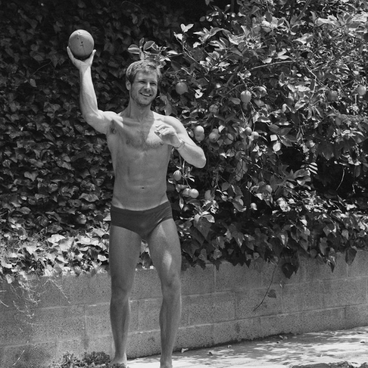 Harrison Ford standing in his underwear, throwing a football.