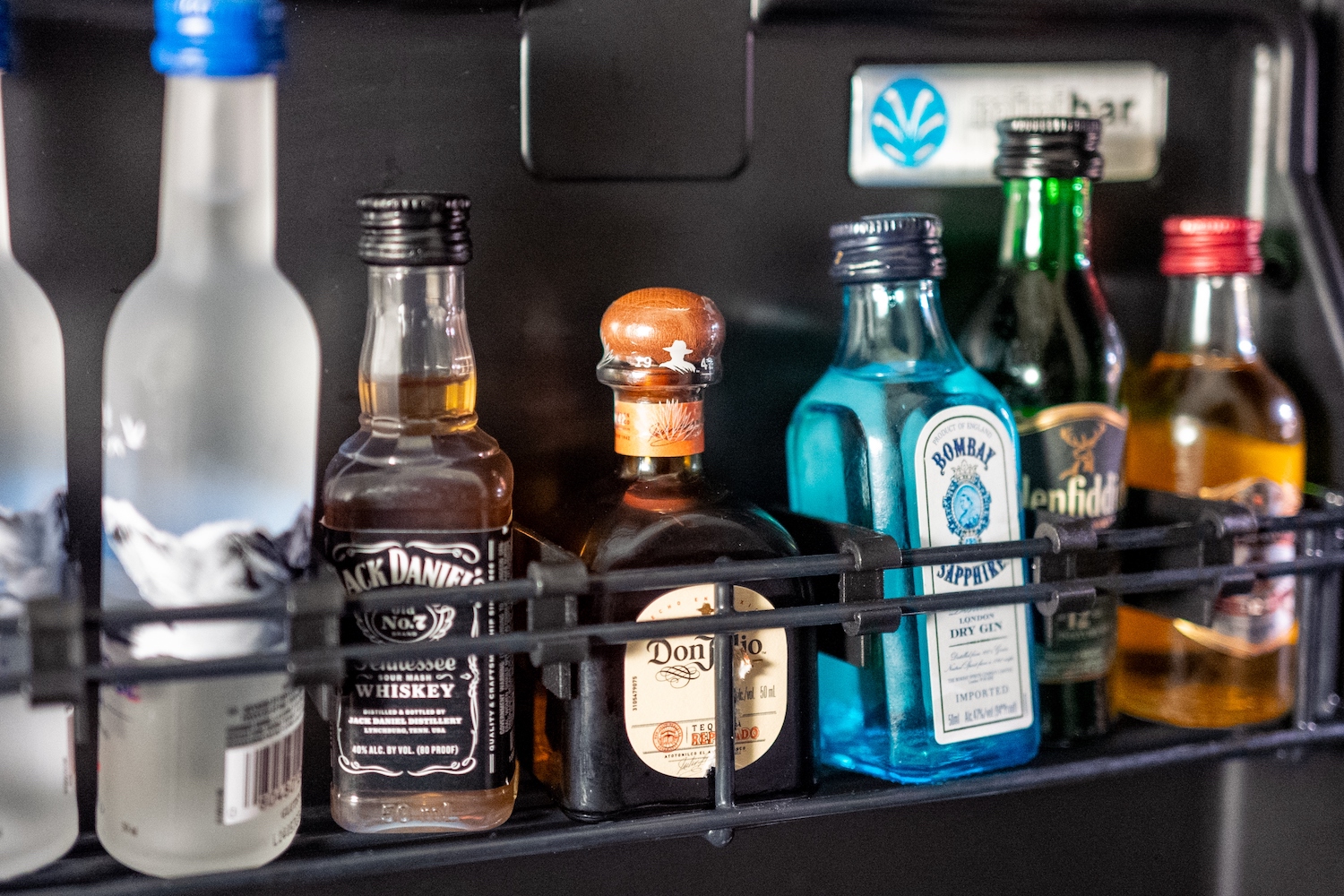 Various drinks are visible inside a hotel minibar refrigerator