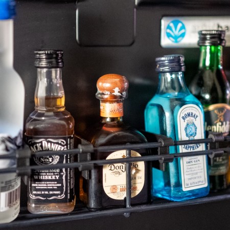 Various drinks are visible inside a hotel minibar refrigerator