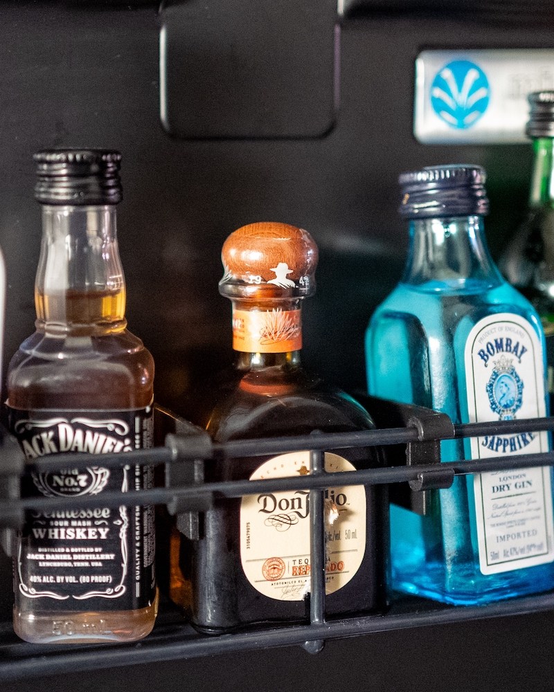 Various drinks are visible inside a hotel minibar refrigerator