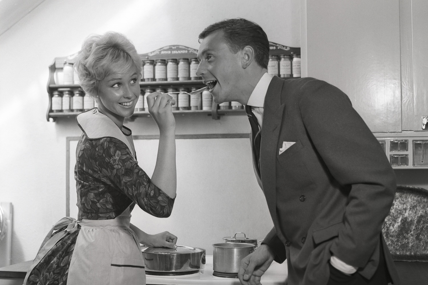 In the kitchen 1950s. A young couple in their kitchen. She is making him taste the food and puts a spoon in his mouth. Sweden 1959 Kristoffersson ref CG35 (Photo by Sjöberg Bildbyrå/ullstein bild via Getty Images)