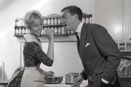 In the kitchen 1950s. A young couple in their kitchen. She is making him taste the food and puts a spoon in his mouth. Sweden 1959 Kristoffersson ref CG35 (Photo by Sjöberg Bildbyrå/ullstein bild via Getty Images)