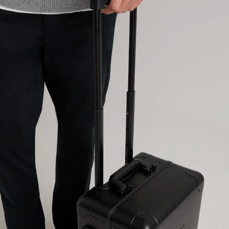 A model rolling a quince suitcase