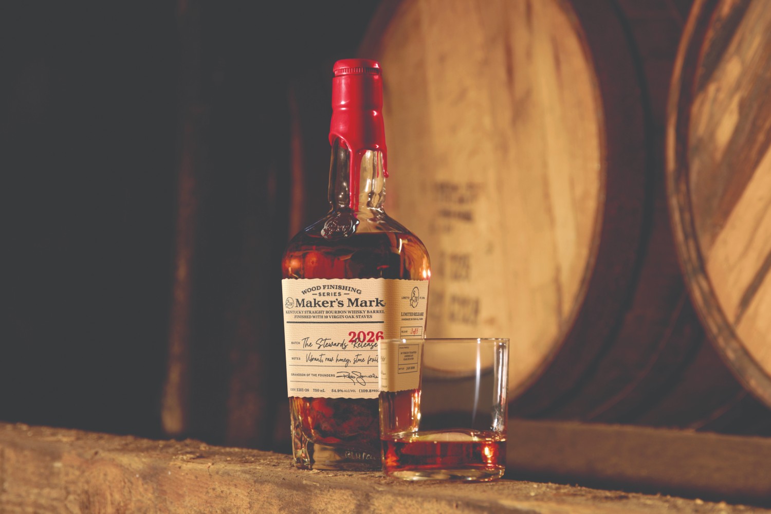 Maker's Mark bottle in front of barrels