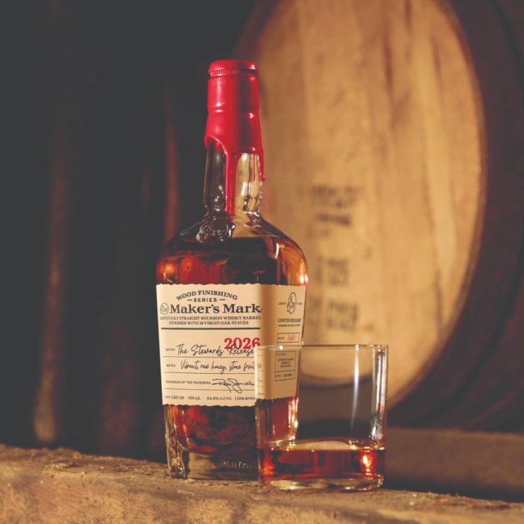 Maker's Mark bottle in front of barrels