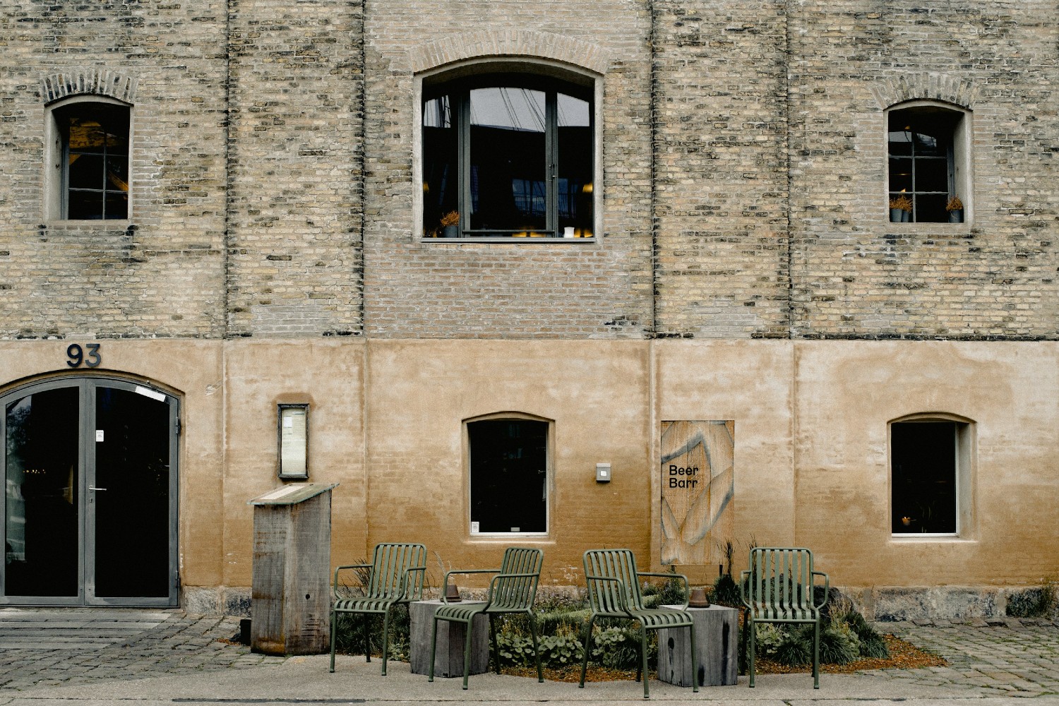 Outside Noma's original location: a brick building with windows and chairs