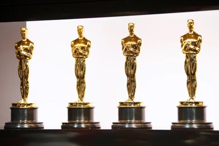 Four Oscar statuettes lined up in a row