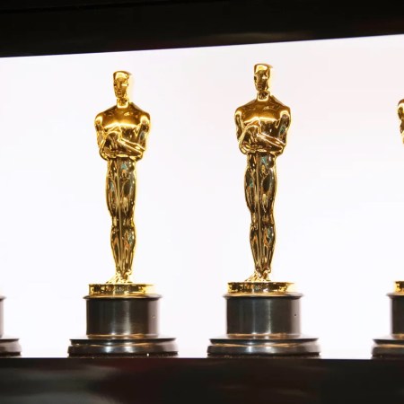 Four Oscar statuettes lined up in a row