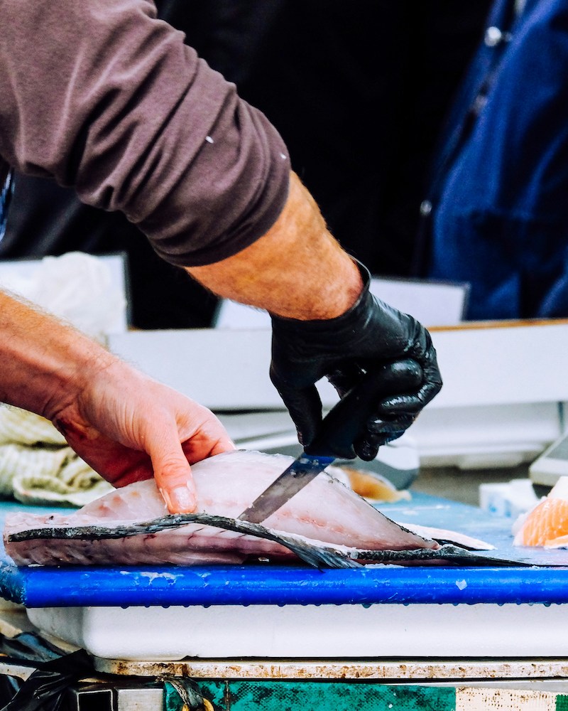 A man cutting a fish.