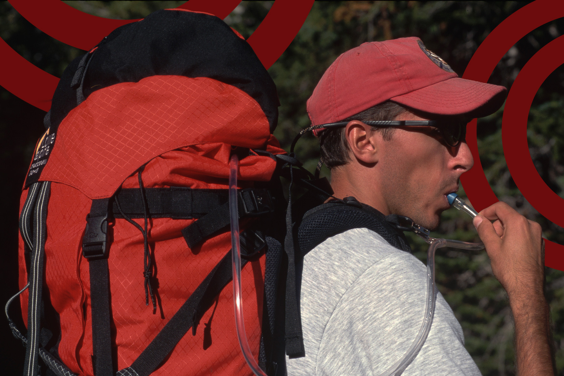 A man hydrates from a large pack.