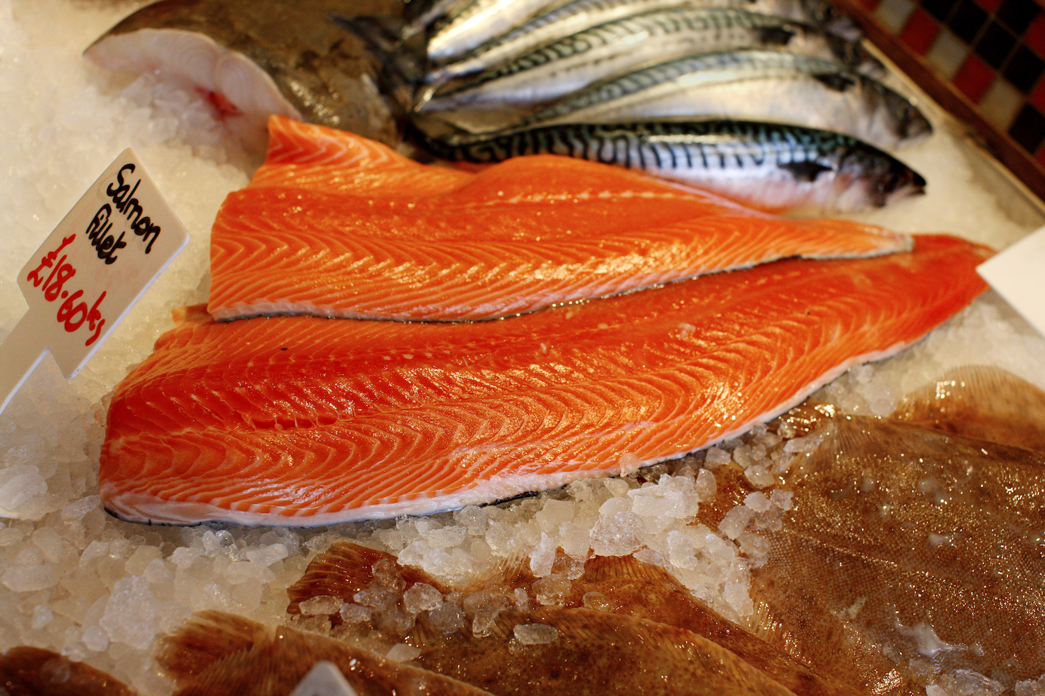 A piece of raw salmon on ice at the fish market.