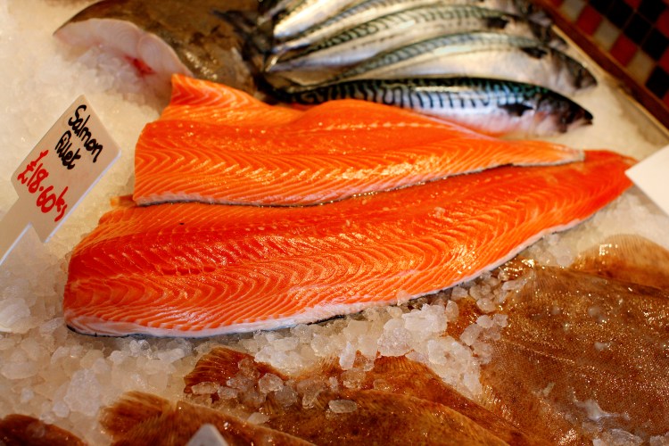 A piece of raw salmon on ice at the fish market.