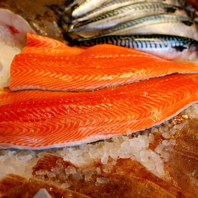 A piece of raw salmon on ice at the fish market.