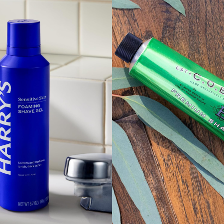 A blue bottle of shaving cream sitting on a sink counter next to a green bottle on a wood counter