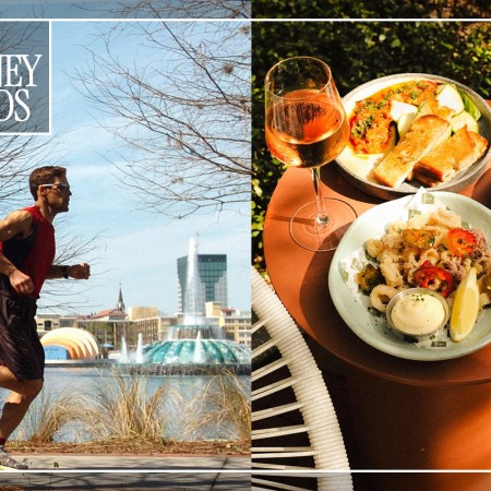 A man running next to a body of water next to a table with three plates of food and a wine glass