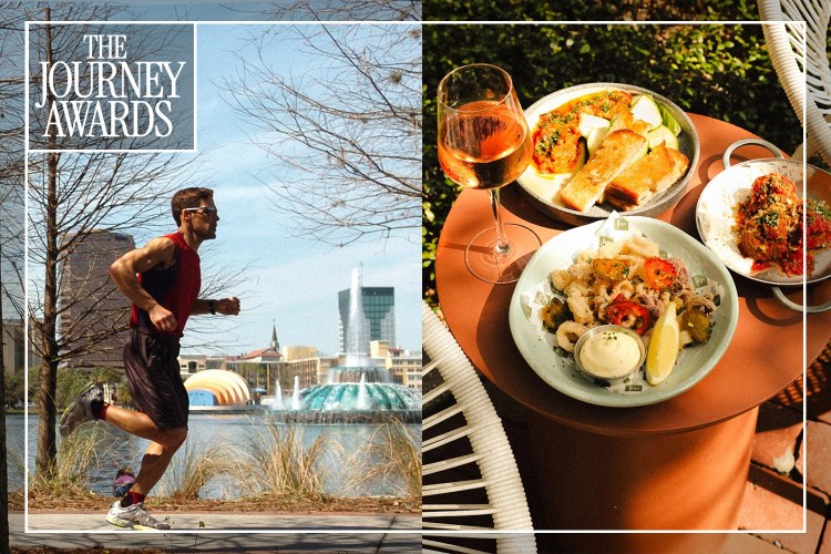 A man running next to a body of water next to a table with three plates of food and a wine glass